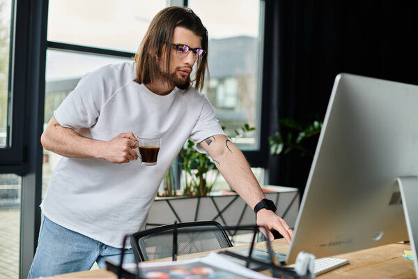 A handsome Caucasian businessman standing in front of a laptop computer, working diligently.
