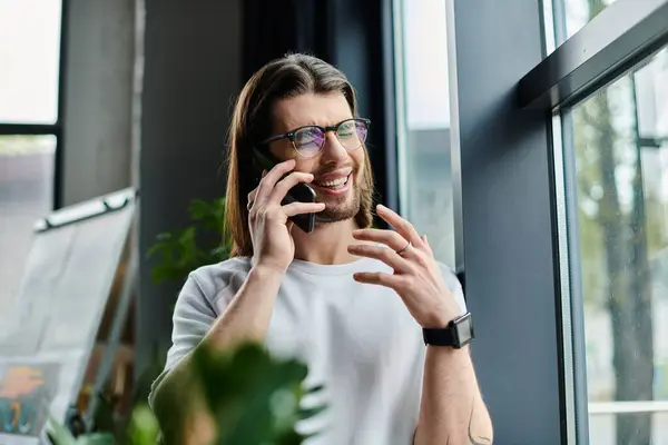 stock image Handsome businessman talking on cell phone next to window.