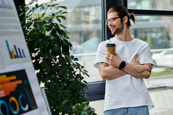 A man, businessman, standing by window, holding coffee cup.