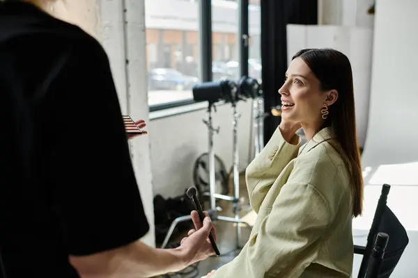 stock image Woman receiving makeup application from talented artist in a chair.