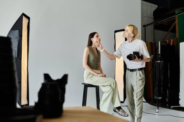 Yaratıcı bir ortamda kadın modelin fotoğrafını çeken bir adam..