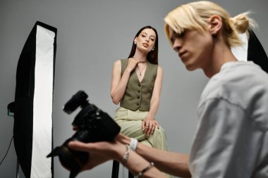 Bir adam yaratıcı stüdyo ortamında bir modelin fotoğraflarını çekiyor..
