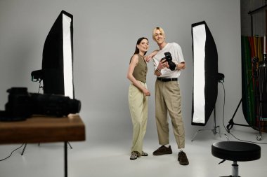 A man shows photos to a woman in a creative collaboration. clipart