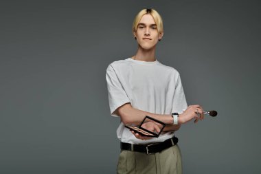 Beyaz tişörtlü şık bir adam nazikçe bir fırça tutuyor..