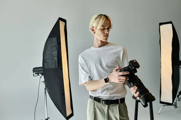 stock image A man poses with a camera in studio.