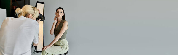 Good looking man taking photos of young woman on camera.