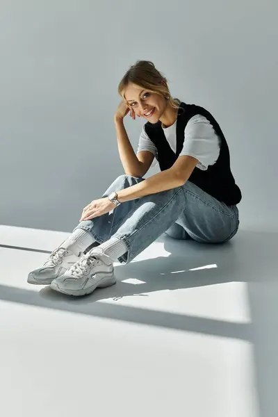 stock image A serene young woman with blonde hair dressed in stylish casual attire