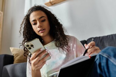 Woman with cell phone on couch. clipart