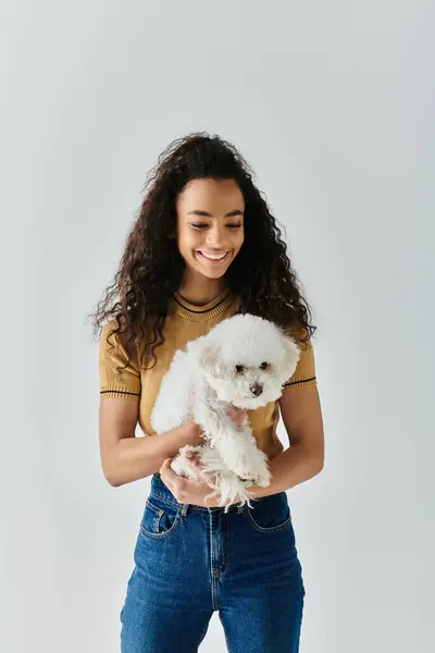 stock image Young woman lovingly cradles her bichon frise in her hands.