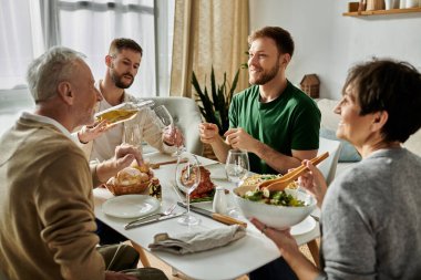 Eşcinsel bir çift evde ailesiyle yemek yiyor..