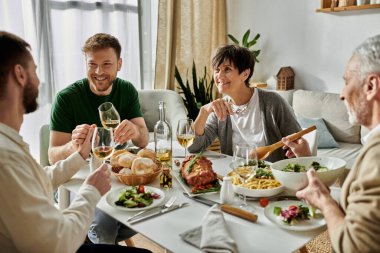 A gay couple shares a meal with parents in a cozy home setting. clipart