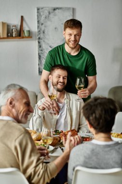 Eşcinsel bir çift ve aileleri evde birlikte yemek yiyor..