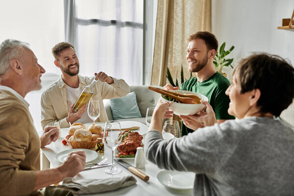 A gay couple enjoys a meal with parents at home.
