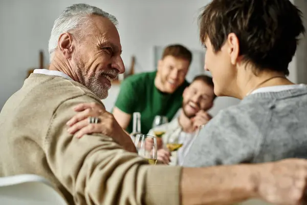 stock image A gay couple smiles as they meet parents at home.