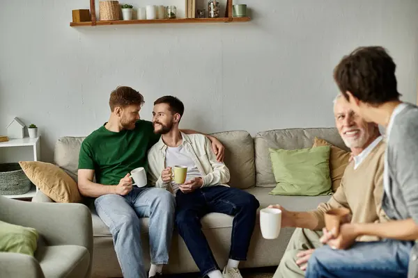 Stock image A gay couple sits on a couch with parents, enjoying a casual and intimate moment together.