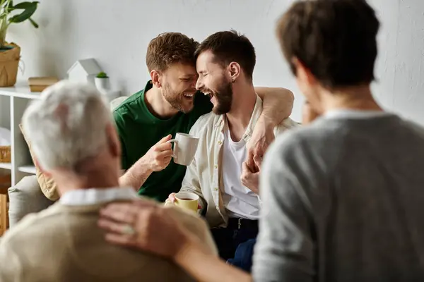 stock image A gay couple shares a laugh with family during a home visit.