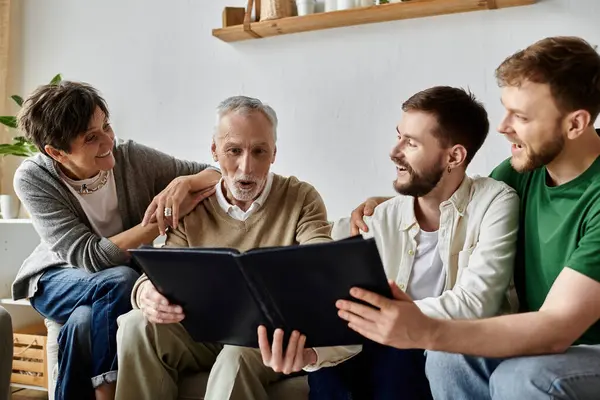stock image A gay couple shares a photo album with parents in their living room.