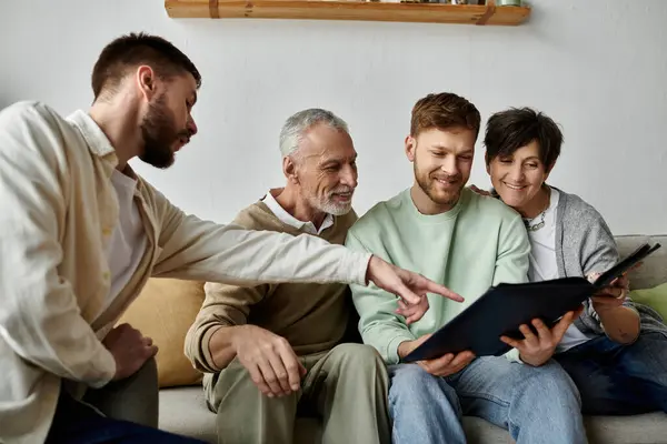stock image A gay couple shares a special moment with parents while looking at a photo album in their home.