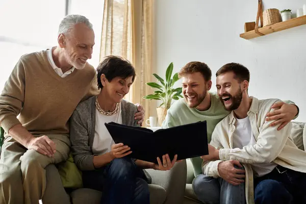 stock image A gay couple shares a photo album with parents, creating a heartwarming moment filled with laughter and affection.