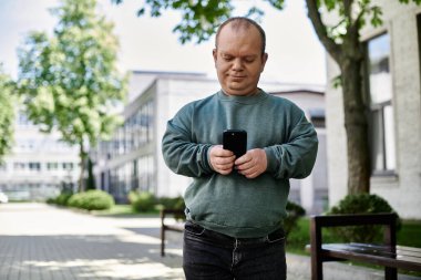Kapsamlı bir adam telefonunu kullanarak şehirde dolaşıyor..
