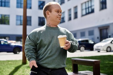 A man with inclusivity walks with a coffee cup in hand, enjoying the urban scenery around him. clipart