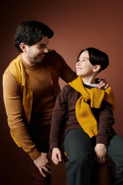 Bir baba ve oğul şefkatli bir anı paylaşır, gözleri sevgi dolu bir bakışla kilitlenir..