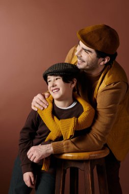 Şapka takan bir baba ve oğul neşeli bir anı paylaşıyor, birlikte gülüyorlar..