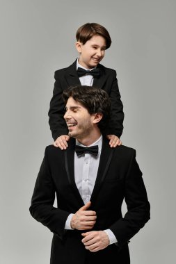 Bir baba ve oğul, siyah kravat takmış neşeli bir anı paylaşır..