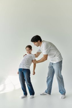 Bir baba ve oğul, beyaz bir odada eğlenceli bir anın tadını çıkarırlar..