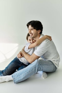 Bir baba ve oğlu sıcacık bir kucaklaşmayı paylaşıyor, ikisi de mutluluktan parlıyor..