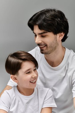 Bir baba ve oğul birlikte gülüyor, yüzleri mutlulukla aydınlanıyor..
