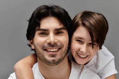 Bir adam mutlu bir şekilde küçük bir çocuğu sırtında taşır, bağlanma ve oyun zamanının tadını çıkarır..