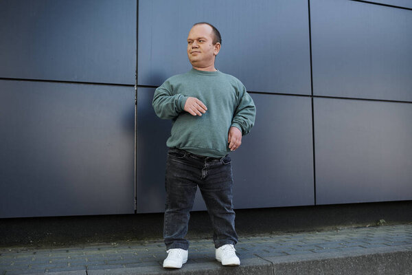 A man with inclusivity stands confidently on a city street, radiating positivity and self-assurance.