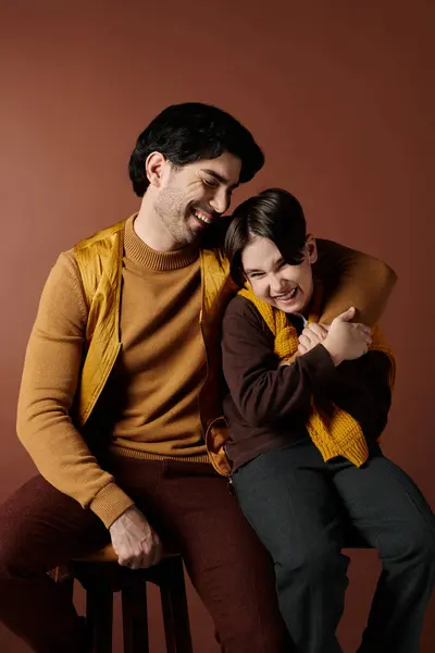 stock image A father and son share a tender moment, laughing together in a studio setting.