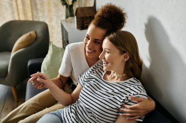 Mutlu bir lezbiyen çift evde rahat bir kanepede dinleniyor..