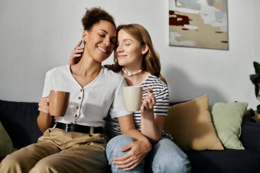 Sevgi dolu bir lezbiyen çift, evde sakin bir sabah geçirir, kahveyi paylaşır ve şefkatle kucaklaşır..