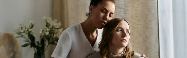 stock image A lesbian couple in casual attire, embracing at home.