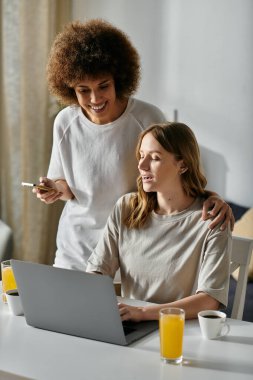 A lesbian couple relaxes at home, enjoying a moment of laughter and connection. clipart