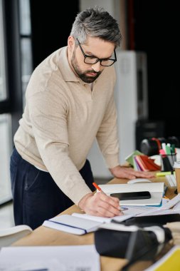 Sakallı yakışıklı bir işadamı modern ofis ortamında işine odaklanır..