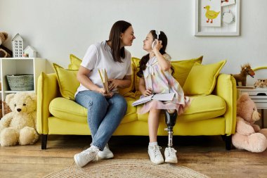 A mother and daughter spend quality time together at home, sharing a comfortable moment on a yellow couch. clipart