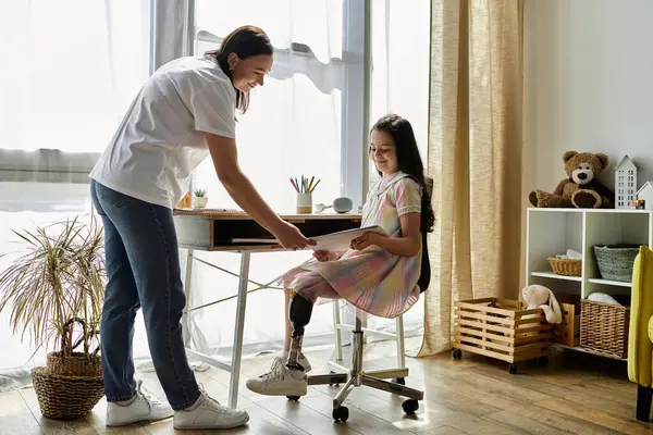 stock image A mother and her daughter with a prosthetic leg enjoy a quiet moment together at home.