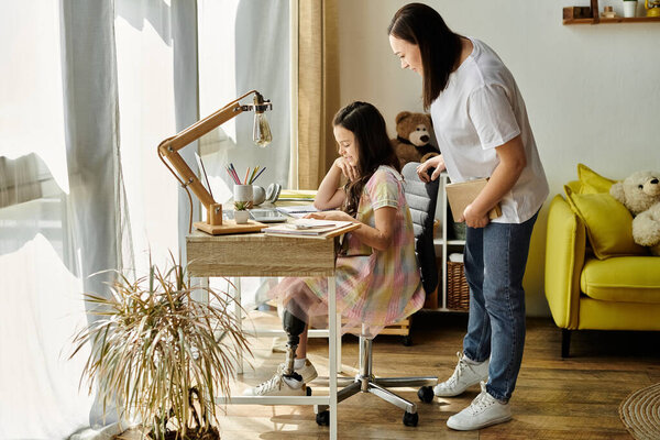 A brunette mother and her daughter, who has a prosthetic leg, are spending quality time at home, working on homework together.
