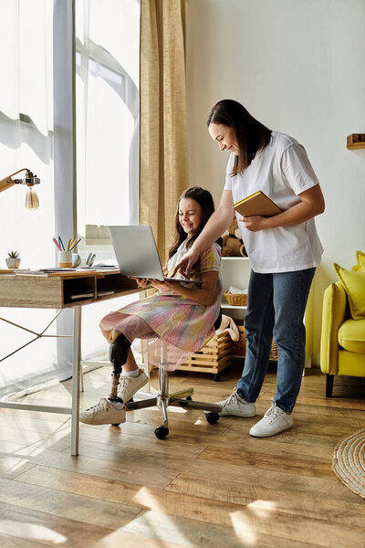 A mother helps her child use a laptop at home. The daughter has a prosthetic leg.
