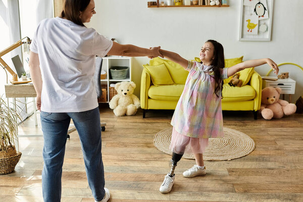 A brunette mother and her daughter, who has a prosthetic leg, dance together in their home.