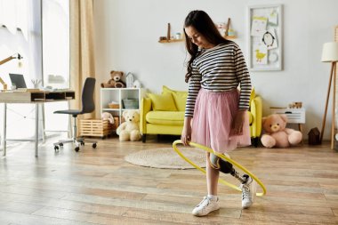 A young girl with a prosthetic leg holds a hula hoop in a home playroom, showcasing her strength and playful spirit. clipart