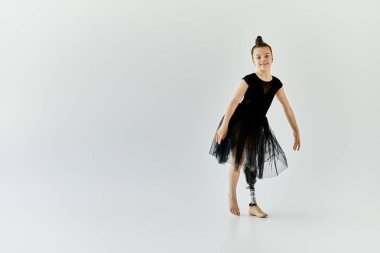 A young girl with a prosthetic leg performs a graceful gymnastics pose. clipart