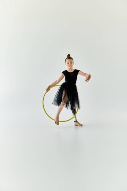 A young girl with a prosthetic leg performs gymnastics with a hula hoop. clipart