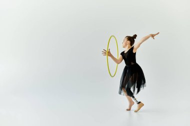 A young girl with a prosthetic leg performs a gymnastic routine with a hoop. clipart