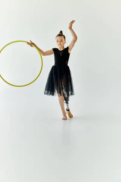 stock image A young girl with a prosthetic leg performs gymnastics with a hoop.