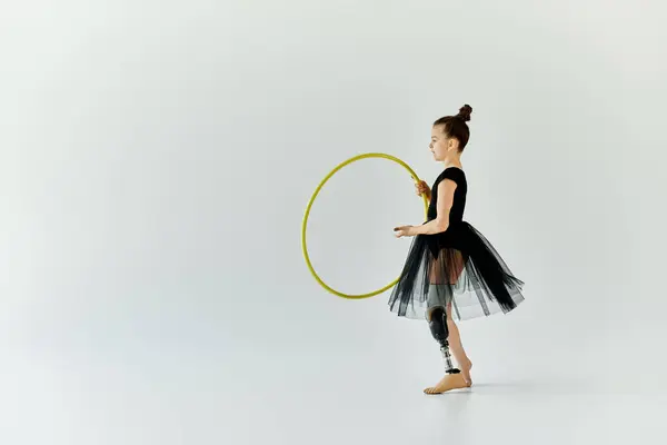 stock image A young girl with a prosthetic leg practices gymnastics with a hoop.